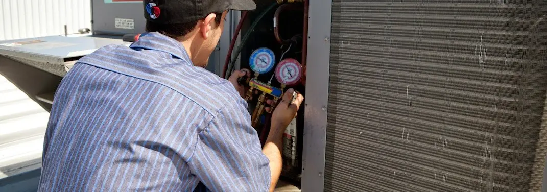 HVAC technician servicing a condenser unit in Fate