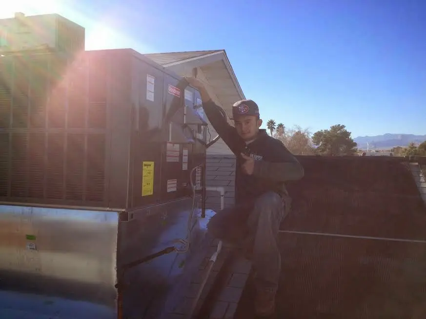 HVAC technician performing AC Tune-Up on a rooftop unit in Fate